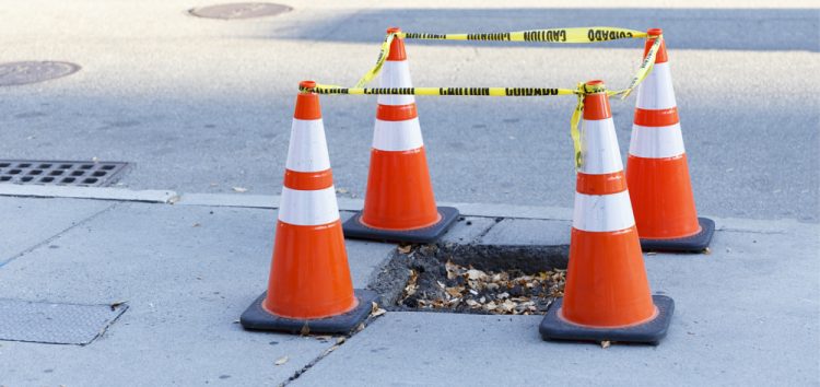 Traffic cones blocking a whole on a footpath