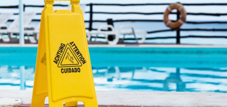 Wet floor warning sign near a swimming pool