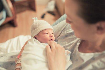 mother in hospital holding and looking down on her baby