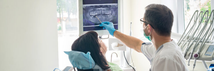 Doctor dentist showing patient's teeth on X-ray